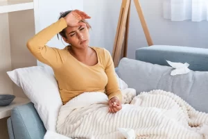 woman sick headache pain bed covid 1